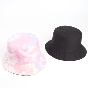 Close-up of pink tie-dye and plain black cotton bucket hats showing fine stitching detail