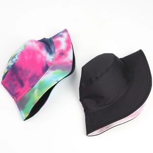 Detail view of reversible tie-dye and solid black bucket hat showing stitching quality