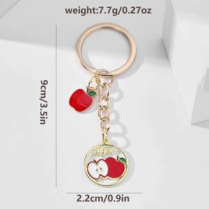 Detail view of red apple keychain showing size dimensions 9cm and weight 7.7g in gold alloy