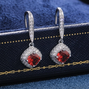 Macro view of square cut ruby red zircon drop earrings with classic claw setting