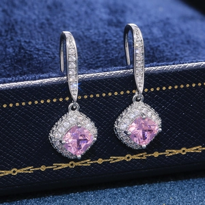Macro detail of square cut pink zircon earrings with silver pavé diamond setting