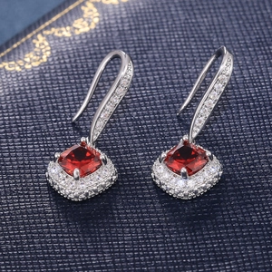 Macro detail of square red gemstone earrings with sparkling zircon pave in silver setting