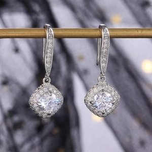 Macro view of square cubic zirconia drop earrings with a halo of small diamonds
