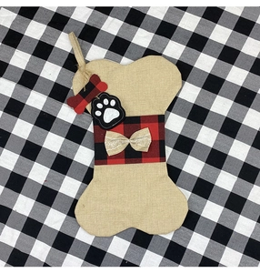 Détail de la chaussette de Noël en forme d'os en toile avec nœud à carreaux rouges
