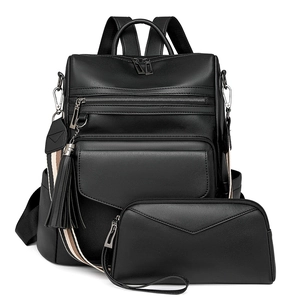 Detail of black faux leather backpack set with tassel charm and striped shoulder strap