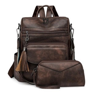 Detailed close-up of brown vintage leather backpack with stylish tassel charm and texture