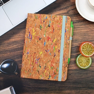 Detailed flat lay of A5 cork notebook set with ink splatter design and blue elastic band