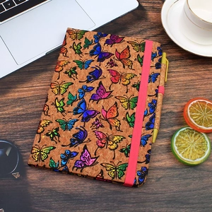 Detail view of cork A5 notebook with colorful butterfly print and red elastic closure band