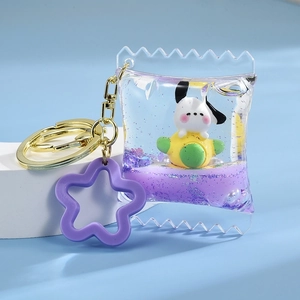 Close-up of a purple dog oil keychain with liquid glitter and a cute star charm