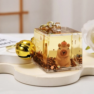 Creative Capybara quicksand bottle keychain with orange hat, gold bell and glitter flakes