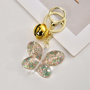 Close-up of a clear acrylic butterfly keychain filled with colorful glitter and gold flakes