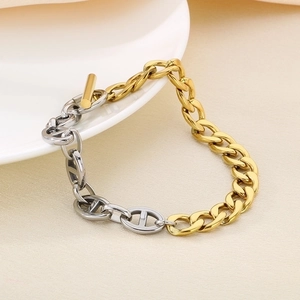 Detail of two-tone gold and silver chain bracelet featuring a T-bar clasp and pig nose links
