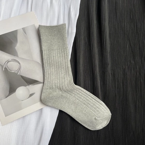 Detailed macro view of gray knitted mid-calf socks with ribbed texture on fabric