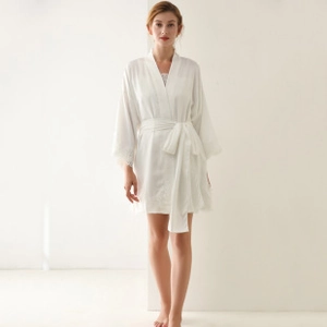 Close-up of white silk bathrobe with delicate lace trim on sleeves and hem for women