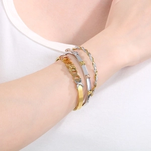 Detailed view of layered 18K gold and silver plated knot bracelets worn on wrist