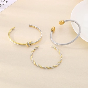 Close-up of knot design and mixed metal twisted textures on 18K gold plated bangles