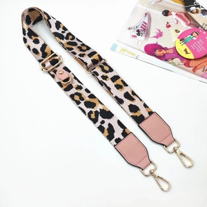 Close-up of leopard print crossbody strap with pink leather and gold metal hooks