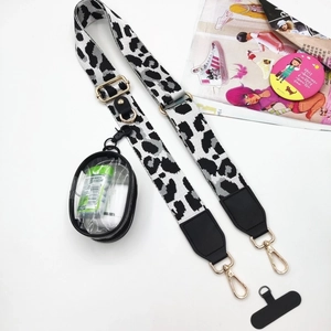 Detail view of leopard print crossbody strap with gold buckles and clear mini pouch attachment