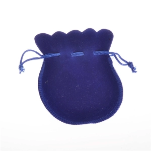 Close-up of deep blue velvet drawstring jewelry pouch with wavy edges and woven cords