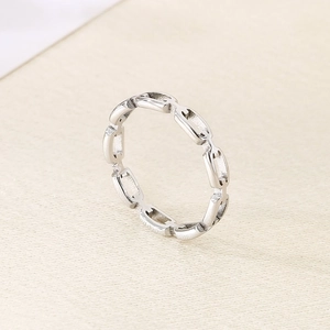 Macro detail of polished stainless steel ring with modern interlocking oval chain design