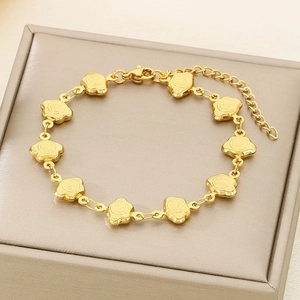 Detail of golden stainless steel bracelet with traditional Fu character charms on leather box