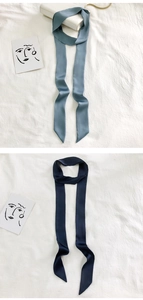 Detail of narrow solid color skinny scarves in blue-grey and dark navy silk texture