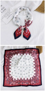 Detail of red and navy paisley silk scarf styled on a book for a lifestyle aesthetic