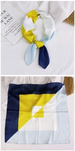 Detail view of square silk scarf with yellow and navy geometric color block patterns