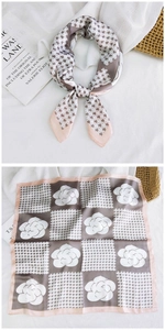 Detail of elegant houndstooth and camellia print silk scarf with stylish knot