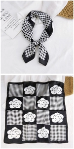 Detail of silk satin scarf featuring houndstooth and camellia prints in black and white