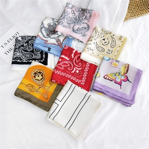 Elegant square silk scarves in paisley, floral, and belt patterns on white fabric