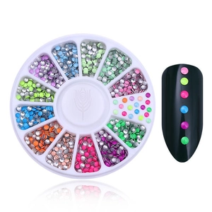 Colorful flatback rhinestones for nail art displayed in a 12-grid wheel storage case