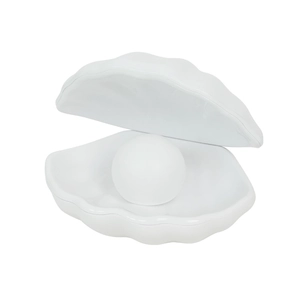 Minimalist white shell-shaped night light with a luminous pearl sphere on a clean background