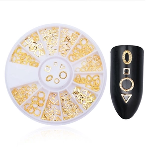 Detailed view of golden alloy nail art studs and hollow shapes in a wheel container