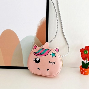Pink cartoon unicorn crossbody bag for girls with silver woven strap on a cozy background