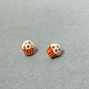 Macro shot of colorful cupcake stud earrings with pink top and sparkling zircon crystals