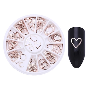Rose gold metal nail charms in a round storage box with a heart-shaped nail art effect