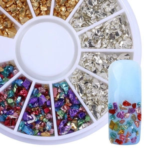 Detail of assorted gold and silver nail art glitters in a white circular divider box