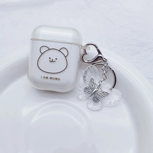 White translucent AirPods case with gold bear print and transparent butterfly keychain