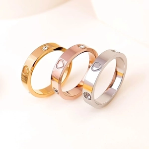 Detail of titanium steel rings with rhinestones and heart cut-outs in three colors