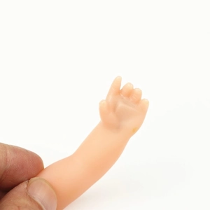 Miniature ghost hand magic prop for coin disappearance trick on clean white background