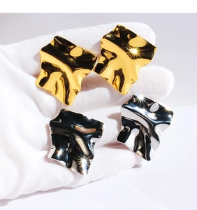 Detailed view of mirror-finish irregular pleated square earrings in gold and silver
