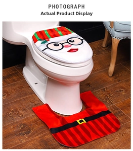 Detail of Christmas toilet set with Santa cover and red black plaid rug on white toilet