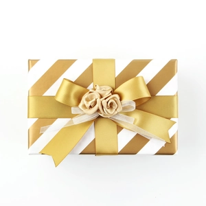 Elegant gold and white striped gift box featuring decorative golden ribbon roses