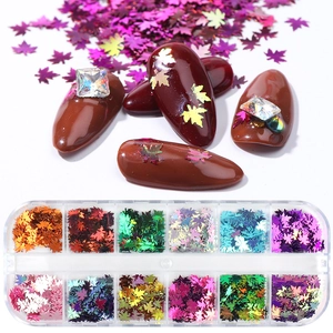 Holographic maple leaf nail art sequins in a 12-grid box with red manicured nail display