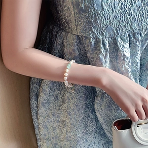Baroque freshwater pearl bracelet with green beads and gold plated clasp on wrist
