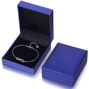 Detail of 925 sterling silver infinity bracelet with elegant blue jewelry gift boxes