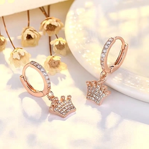 Detailed view of rose gold crown drop earrings with pavé white zircon stones
