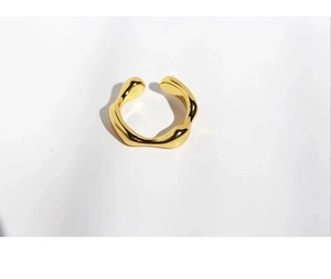 Macro shot of minimalist gold irregular wave ring with smooth polished metallic finish