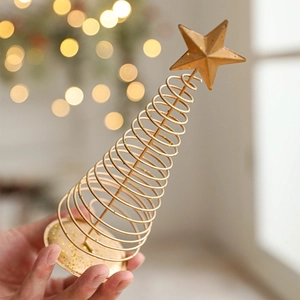Golden spiral iron Christmas tree centerpiece with star topper and festive warm background